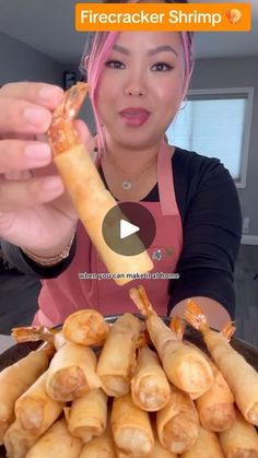 a woman holding up a piece of food in front of her face with the caption firecracker shrimp