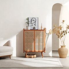 a living room with white walls and wicker furniture on the floor next to a potted plant