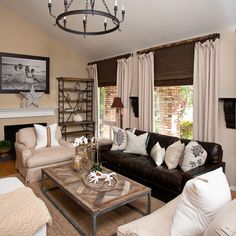 a living room filled with furniture and a chandelier hanging from the ceiling over a fire place