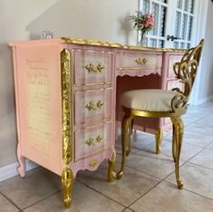 a pink and gold desk with a chair next to it