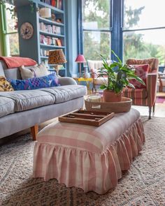 a living room filled with furniture and a large window covered in bookshelf windows