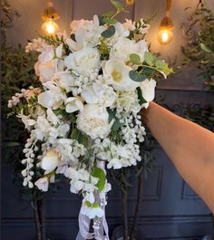 a bouquet of white flowers is being held by someone