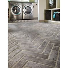 a washer and dryer in a room with stone flooring on the ground