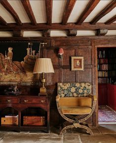 a room with wooden paneling and an old fashioned chair in front of a painting on the wall