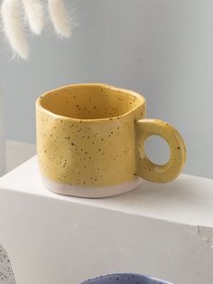 a yellow cup sitting on top of a white table