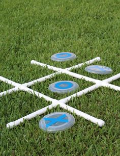 several white and blue frisbees sitting on top of the grass in front of each other