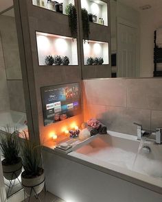 a bath tub sitting next to a bathroom sink with candles on the side of it