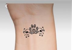 a small tattoo on the side of a woman's arm with an ornamental design