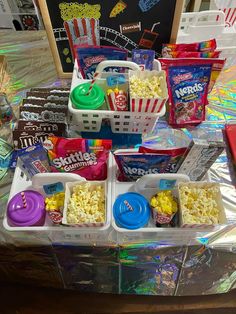 several baskets filled with popcorn and candy on top of a table