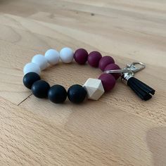 a bracelet with beads and tassels on a wooden table