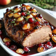 a piece of meat with cranberry sauce and potatoes on it in a white dish