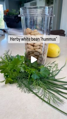 a blender filled with nuts and greens on top of a counter next to lemons