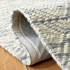 a close up view of the corner of a rug with wood flooring and wooden floors