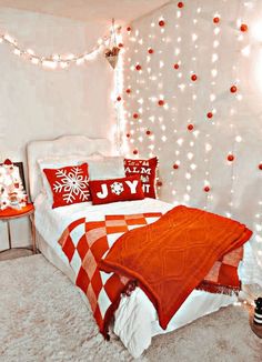 a bedroom decorated in red and white with christmas lights