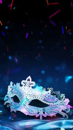 a masquerade mask with confetti and streamers in the back ground