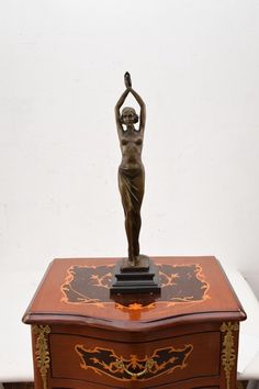 a small wooden box with a statue on top