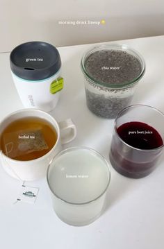 there are four different types of teas on the table with each one in their own cup