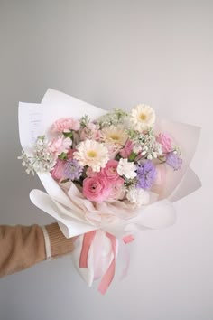 a person holding a bouquet of flowers in their hand