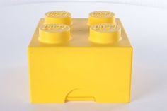 a yellow lego block with three small bottles on top