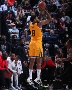 a basketball player is jumping up to dunk the ball in front of an audience