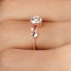 a close up of a person's hand with a diamond ring on their finger