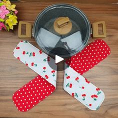 three pieces of red and white polka dot ribbon next to an iron pot with lid