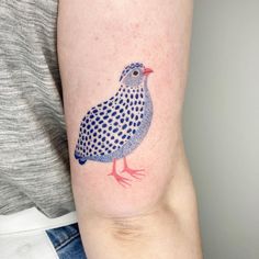 a small blue bird tattoo on the right arm and shoulder, with dots all over it's body