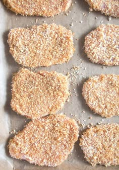 several pieces of breaded pastries sitting on top of a piece of parchment paper