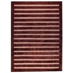 a brown and pink rug with horizontal stripes on the bottom, in front of a white background