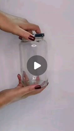 a person holding a glass jar in their hand and touching it with the other hand