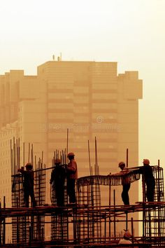 construction workers are standing on scaffolding in front of the cityscape royalty photo