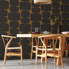 a dining room table with chairs and a vase on top of it next to a wall