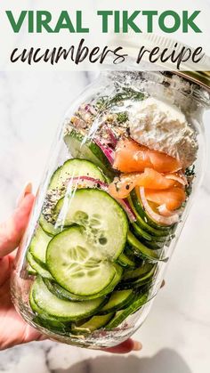 a mason jar filled with cucumbers, carrots and other veggies