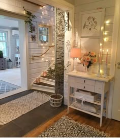 a living room with white furniture and lights on the wall