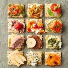 an assortment of appetizers on crackers with fruit and vegetables arranged in squares