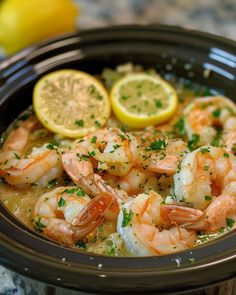 a close up of a bowl of food with shrimp and lemons on the side