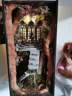 a doll is sitting in a miniature house