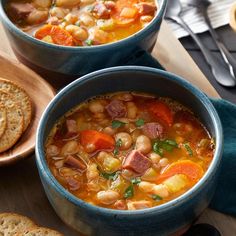 two bowls filled with soup next to some crackers