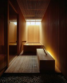 a wooden room with two benches and lights on the wall, along with gravel flooring