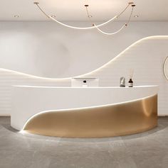 a white and gold reception counter in a modern office space with circular lights hanging from the ceiling