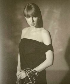 black and white photograph of a woman in an off shoulder dress holding a handbag