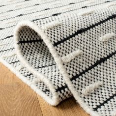 a close up view of a rug on the floor with wood floors in the background