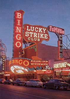 the neon signs are lit up on the side of the building in front of the casino