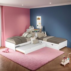 a child's bedroom with pink and blue walls, white bed frames and drawers