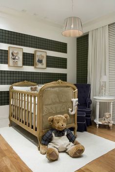 a teddy bear sitting in the middle of a baby's crib with two pictures on the wall