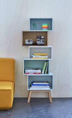 a yellow chair sitting next to a book shelf