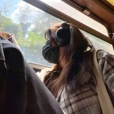 a woman wearing headphones while sitting on a bus