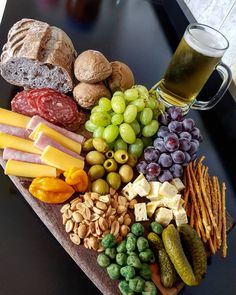 a heart shaped platter filled with cheese, crackers, grapes, nuts and meats