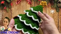 a crochet christmas tree ornament being held by a woman