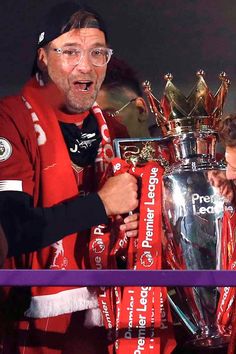 two men are holding up the trophy together